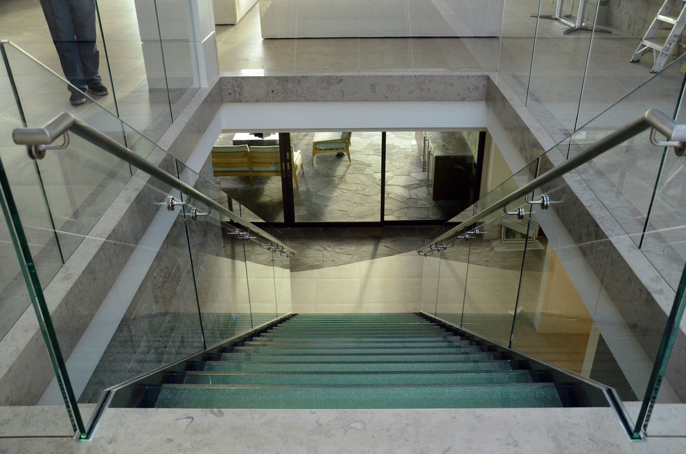 Ejemplo de escalera recta minimalista de tamaño medio sin contrahuella con escalones de vidrio