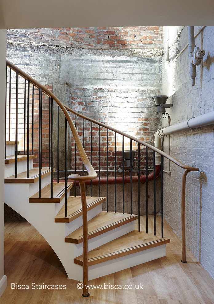 Diseño de escalera en U urbana grande con escalones de madera y contrahuellas de madera pintada
