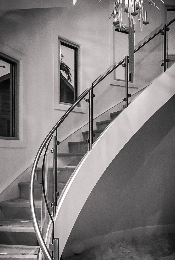 Inspiration pour un très grand escalier courbe minimaliste avec des marches en bois et des contremarches en verre.
