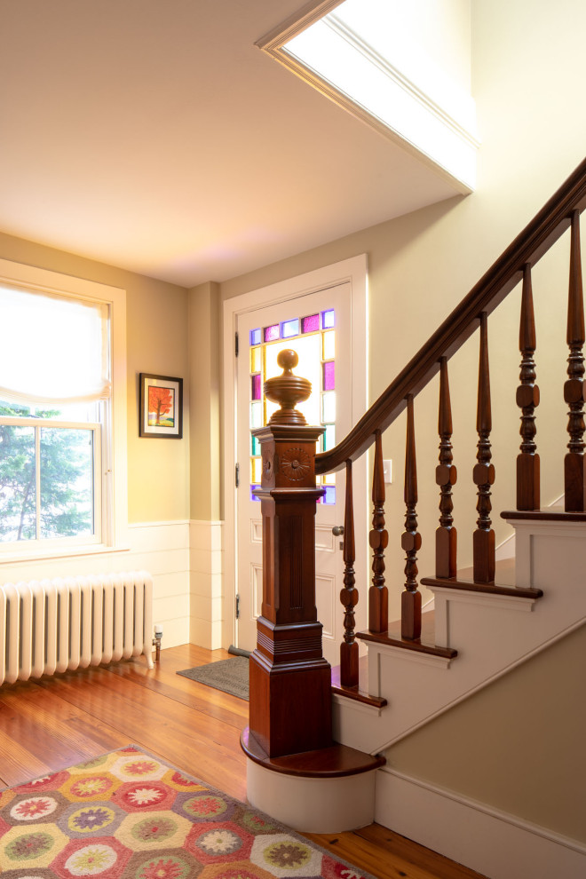 На фото: угловая лестница среднего размера в классическом стиле с деревянными ступенями и крашенными деревянными подступенками