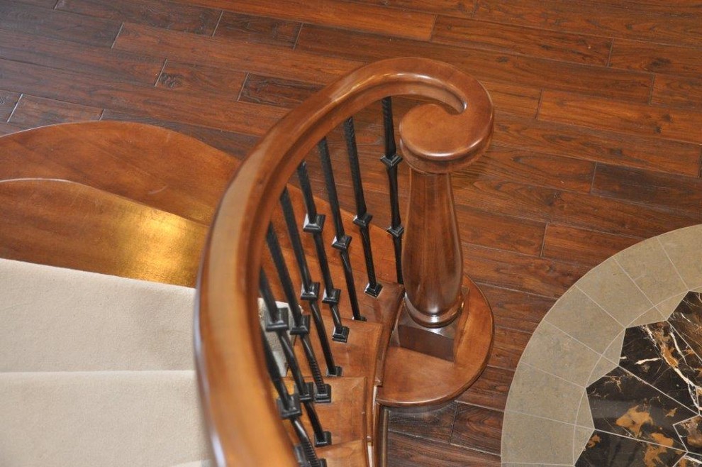 Пример оригинального дизайна: большая изогнутая деревянная лестница в средиземноморском стиле с деревянными ступенями