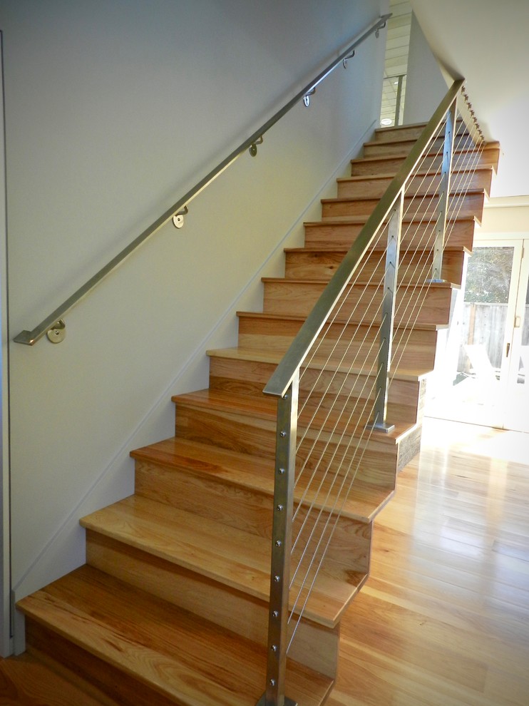 Пример оригинального дизайна: деревянная лестница на больцах, среднего размера в стиле ретро с деревянными ступенями и перилами из тросов