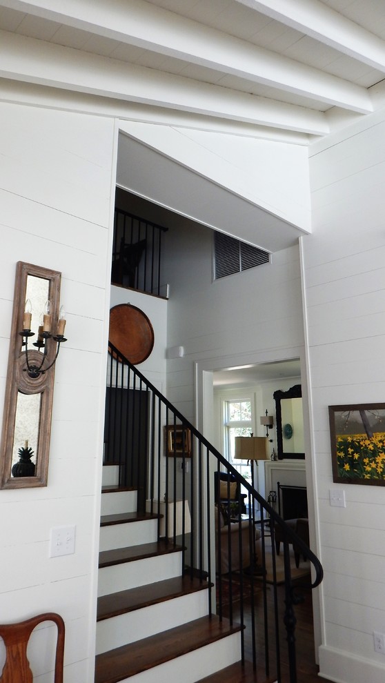 Imagen de escalera en L clásica de tamaño medio con escalones de madera, contrahuellas de madera y barandilla de metal