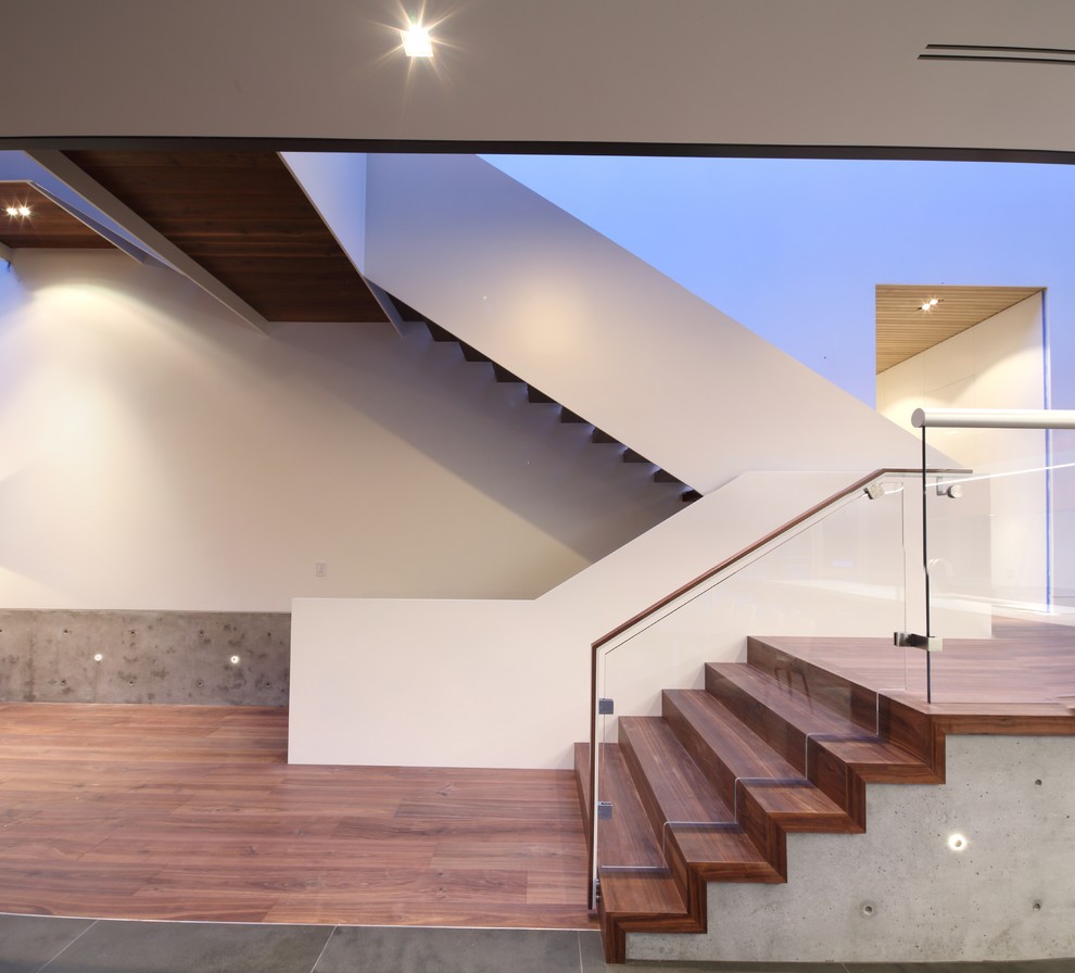 Aménagement d'un grand escalier moderne en U avec des marches en bois et des contremarches en bois.