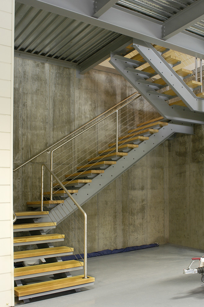 Diseño de escalera en L industrial grande sin contrahuella con escalones de madera