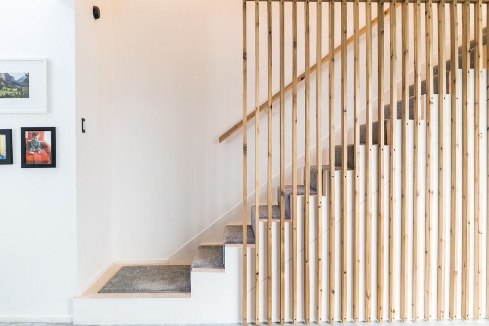 Свежая идея для дизайна: прямая лестница среднего размера в стиле модернизм с деревянными перилами - отличное фото интерьера