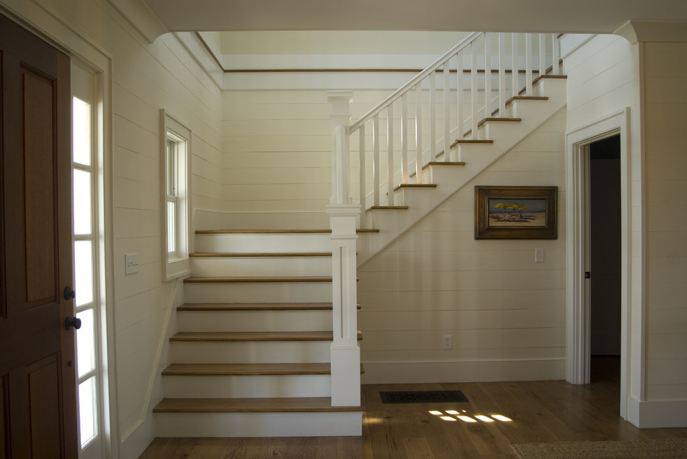 Large elegant wooden l-shaped wood railing staircase photo in Boston with painted risers