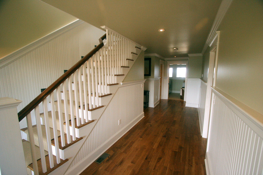 Inspiration for a mid-sized coastal wooden straight staircase remodel in Other with painted risers