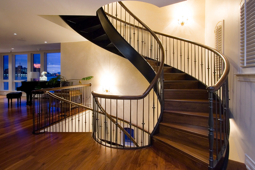 Imagen de escalera curva tradicional con escalones de madera y contrahuellas de madera