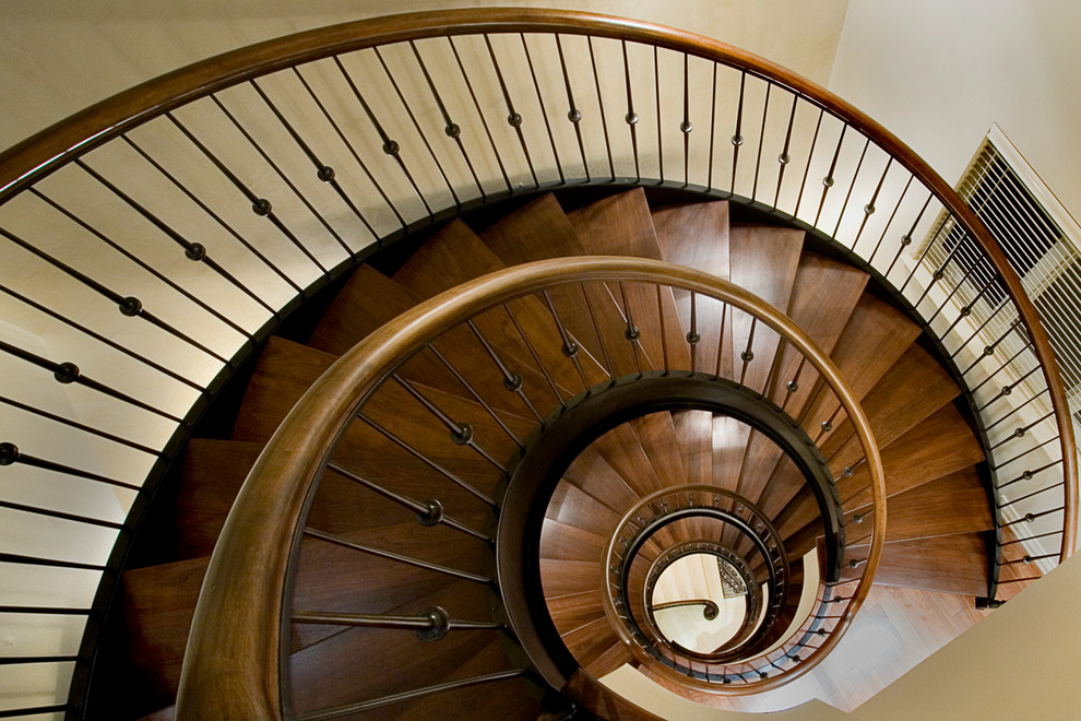 Imagen de escalera curva clásica con escalones de madera y contrahuellas de madera
