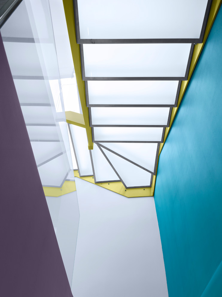 Foto de escalera actual de tamaño medio sin contrahuella con escalones de vidrio y barandilla de vidrio