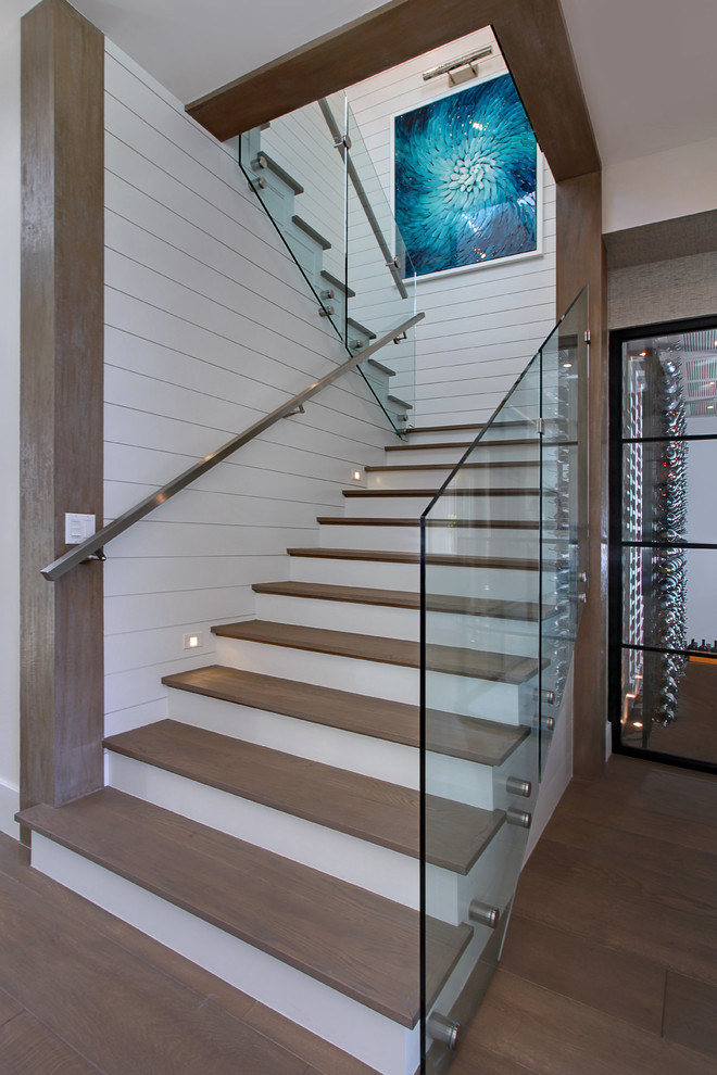 Photo of a coastal wood u-shaped staircase in Orange County with painted wood risers.