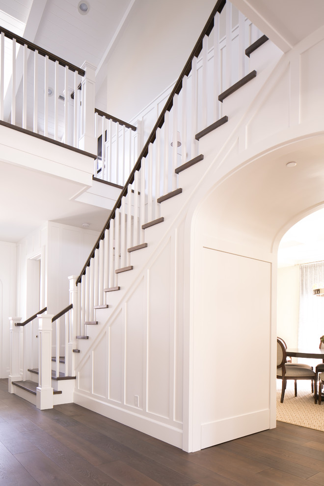 Идея дизайна: большая угловая лестница в стиле неоклассика (современная классика) с деревянными ступенями и крашенными деревянными подступенками