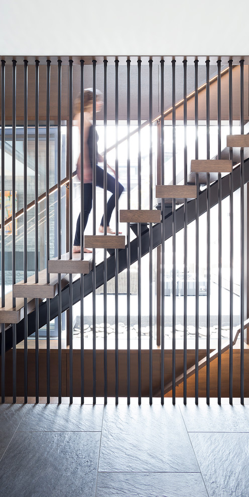 Foto de escalera recta contemporánea de tamaño medio sin contrahuella con escalones de madera y barandilla de madera