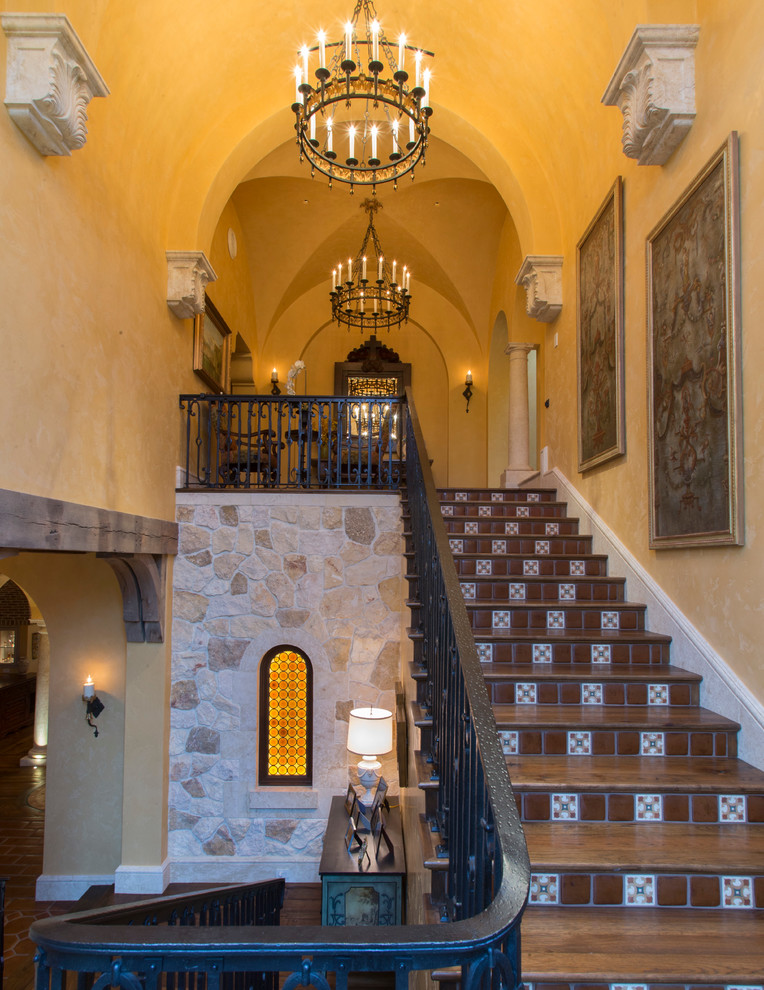 Staircase - mid-sized mediterranean wooden u-shaped metal railing staircase idea in Miami with tile risers