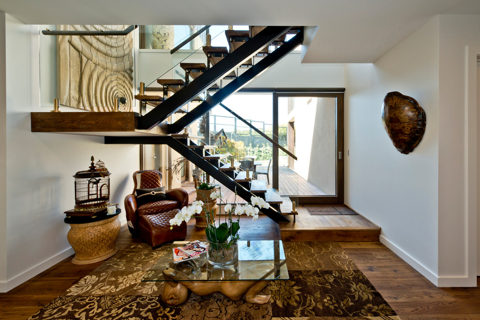 Foto de escalera en U contemporánea sin contrahuella con escalones de madera y barandilla de vidrio