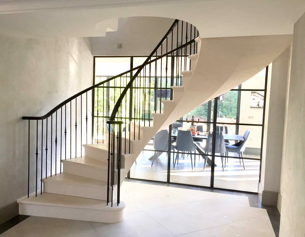 Пример оригинального дизайна: изогнутая лестница среднего размера в современном стиле с ступенями из известняка и подступенками из известняка