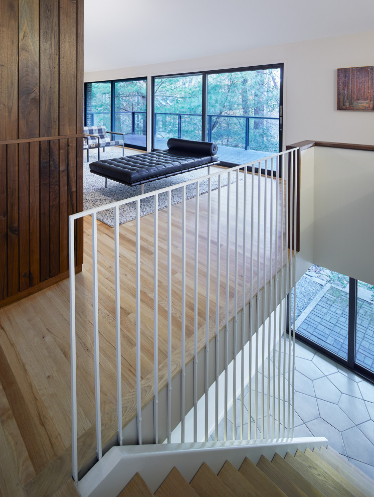 Imagen de escalera recta retro con escalones de madera, contrahuellas de madera y barandilla de metal