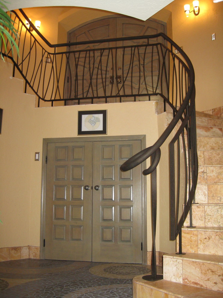 アルバカーキにあるエクレクティックスタイルのおしゃれな折り返し階段 (タイルの蹴込み板、金属の手すり) の写真