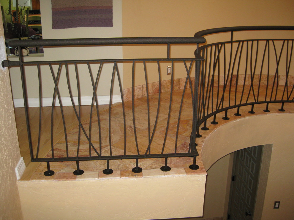 На фото: п-образная лестница в стиле фьюжн с ступенями из плитки, подступенками из плитки и металлическими перилами