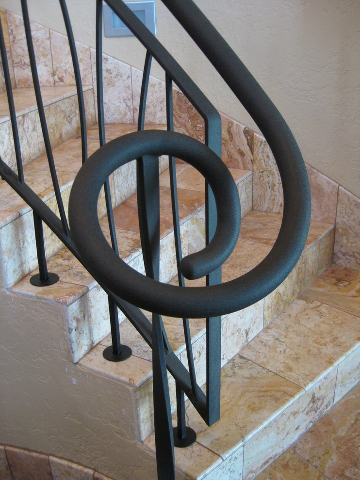 Ejemplo de escalera en U ecléctica con escalones con baldosas, contrahuellas con baldosas y/o azulejos y barandilla de metal