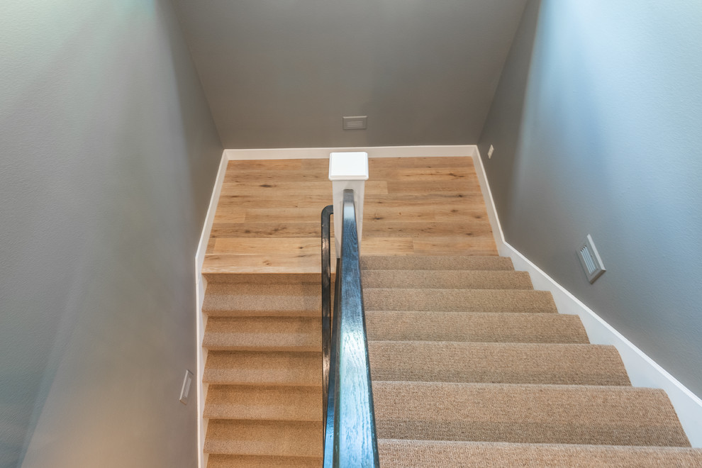 Imagen de escalera en U de estilo de casa de campo con escalones enmoquetados, contrahuellas enmoquetadas y barandilla de metal