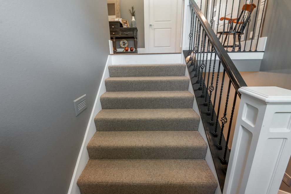 Пример оригинального дизайна: п-образная лестница в стиле кантри с ступенями с ковровым покрытием, ковровыми подступенками и металлическими перилами