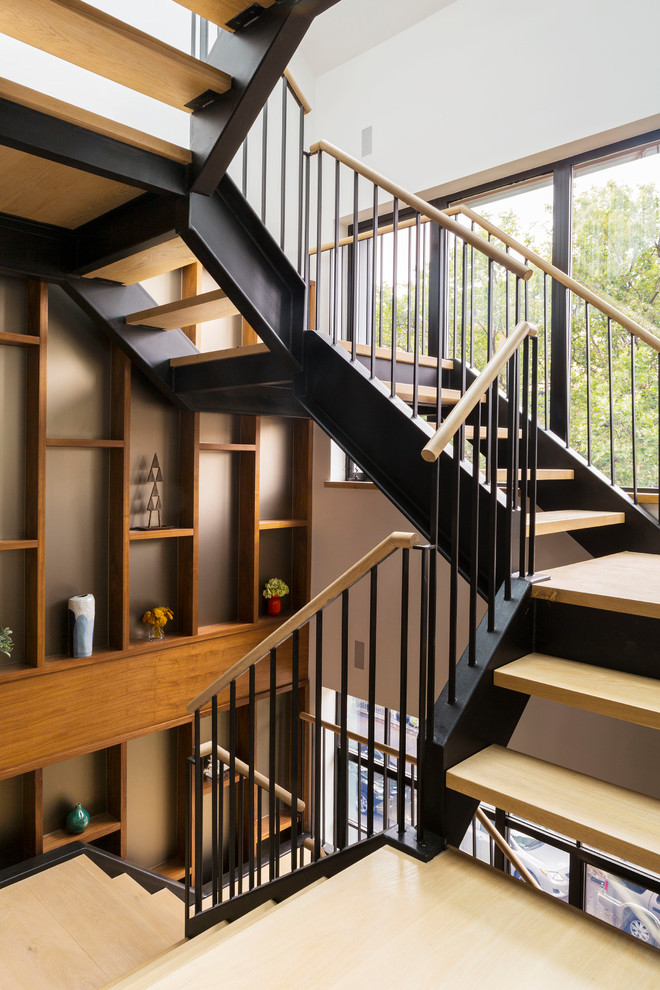 На фото: огромная металлическая лестница на больцах в современном стиле с деревянными ступенями и деревянными перилами