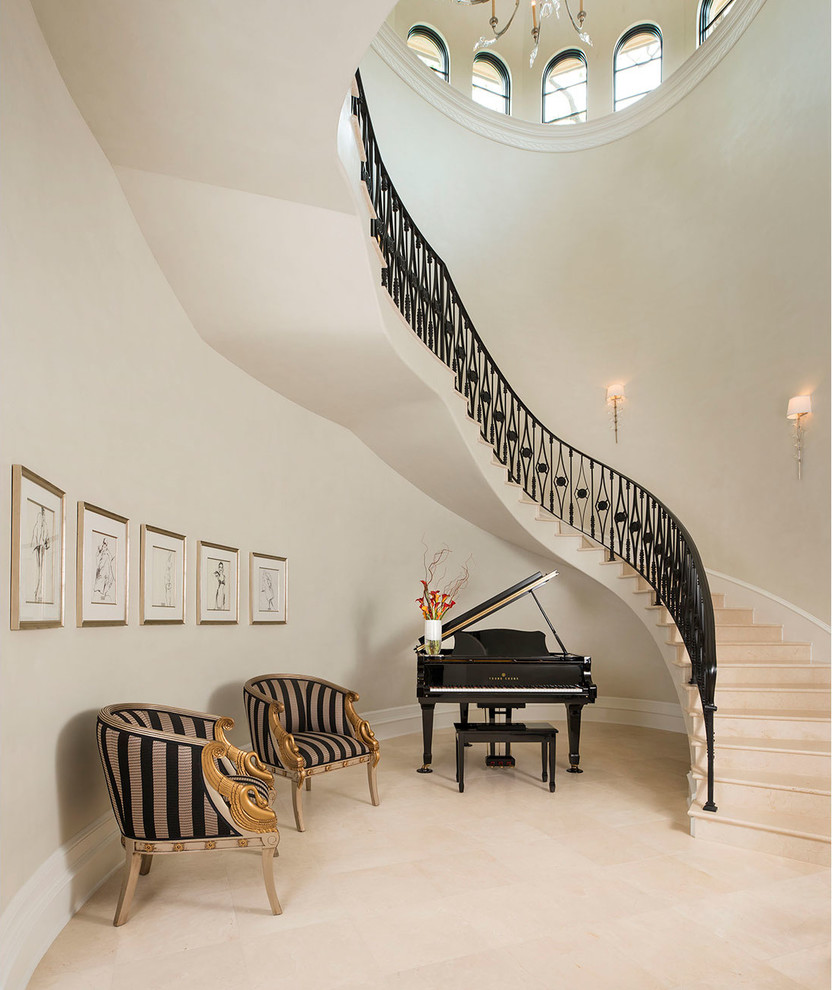 Идея дизайна: огромная изогнутая лестница в средиземноморском стиле с металлическими перилами, ступенями из известняка и подступенками из известняка