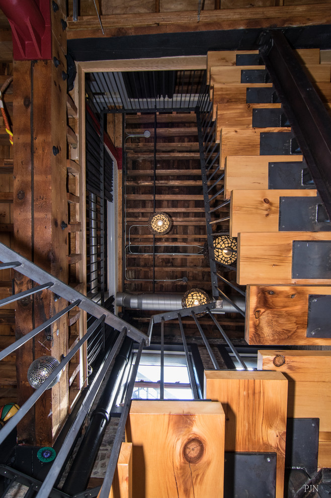Imagen de escalera suspendida ecléctica sin contrahuella con escalones de madera y barandilla de metal