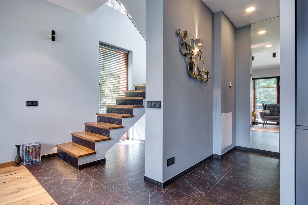 Réalisation d'un escalier droit design de taille moyenne avec des marches en bois et des contremarches en marbre.