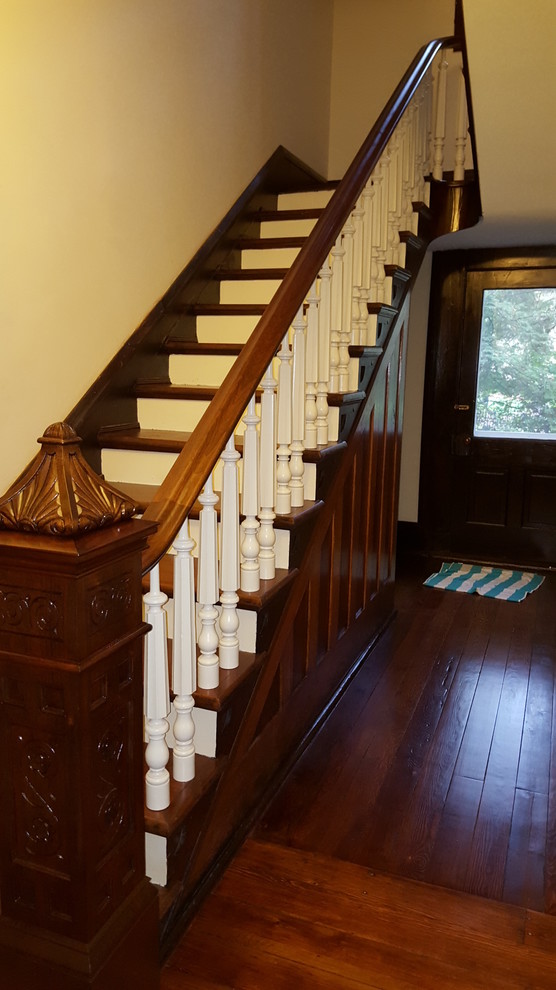 Diseño de escalera recta tradicional de tamaño medio con escalones de madera, contrahuellas de madera pintada y barandilla de madera