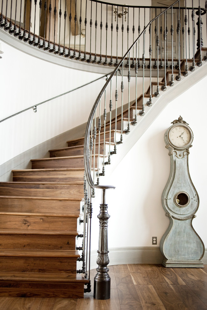 Источник вдохновения для домашнего уюта: изогнутая деревянная лестница в классическом стиле с деревянными ступенями и металлическими перилами