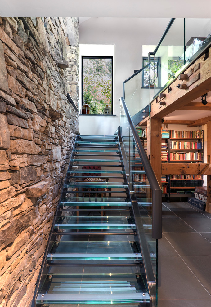 Aménagement d'un escalier sans contremarche contemporain en L avec des marches en verre.