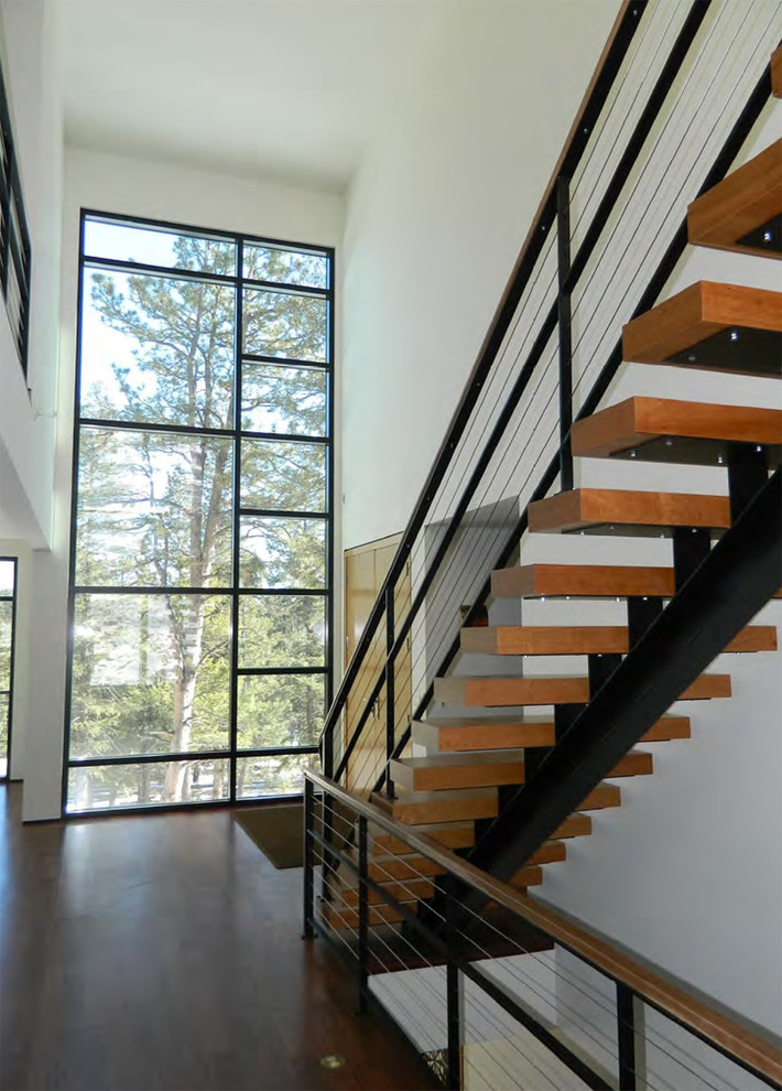 Imagen de escalera recta contemporánea sin contrahuella con escalones de madera y barandilla de cable