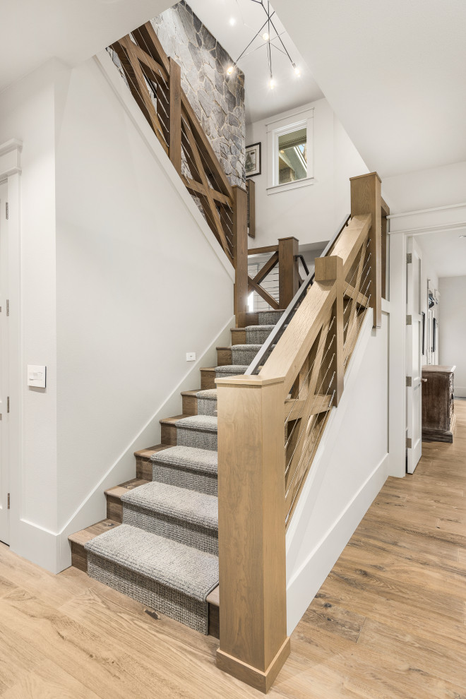 Inspiration for a large transitional wooden u-shaped mixed material railing staircase remodel in Portland with wooden risers