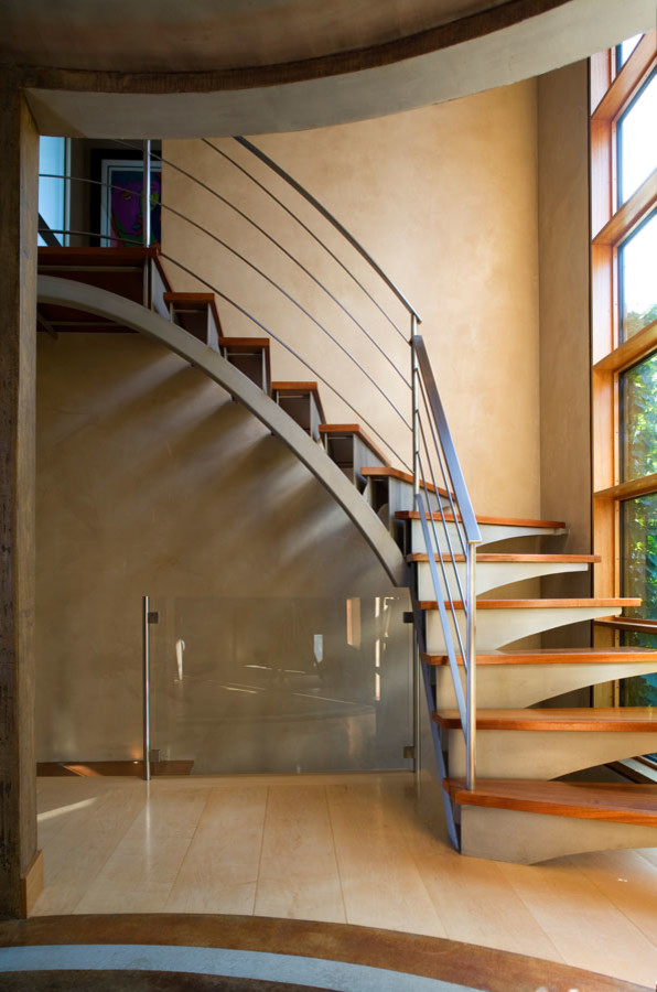 Cette photo montre un grand escalier hélicoïdal moderne avec des marches en bois et des contremarches en métal.