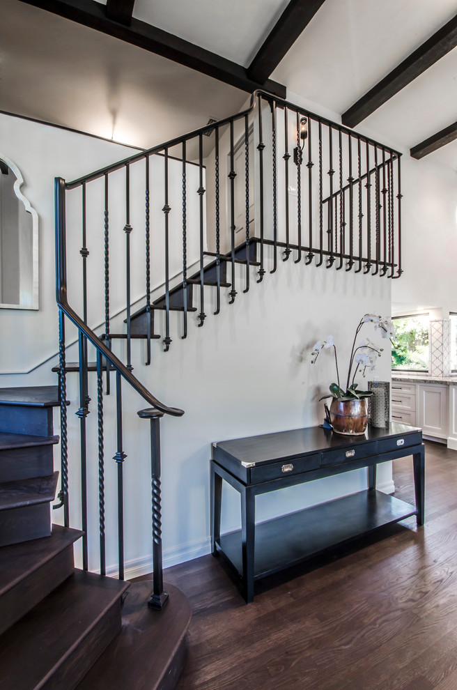 This is an example of an expansive mediterranean wood curved staircase in Santa Barbara with wood risers.