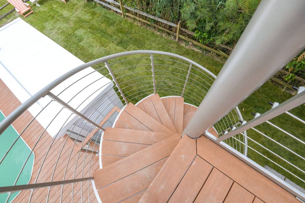 This is an example of a nautical wood spiral metal railing staircase in Other with open risers.