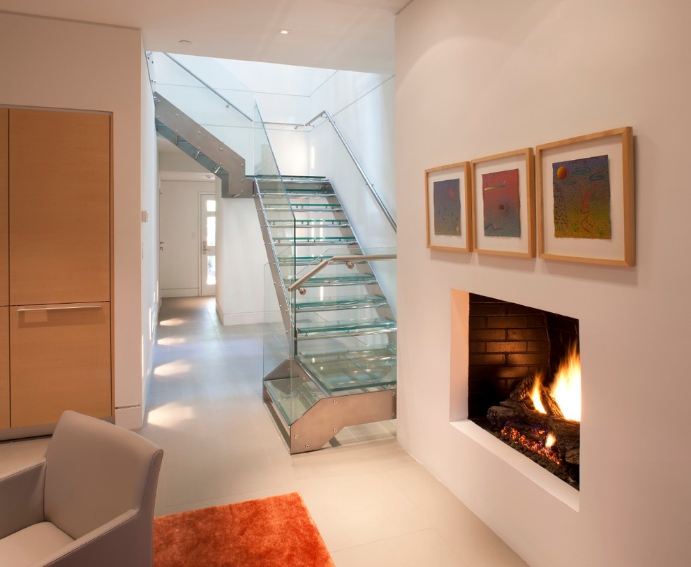 Idées déco pour un escalier contemporain en L de taille moyenne avec des marches en verre et des contremarches en métal.