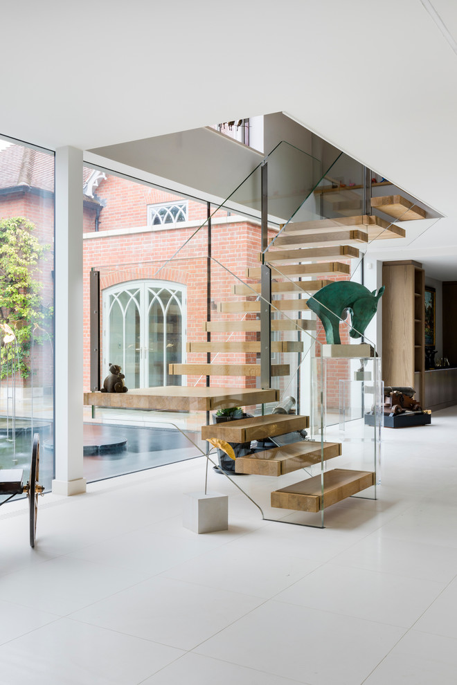 Contemporary wood l-shaped glass railing staircase in Wiltshire with open risers.
