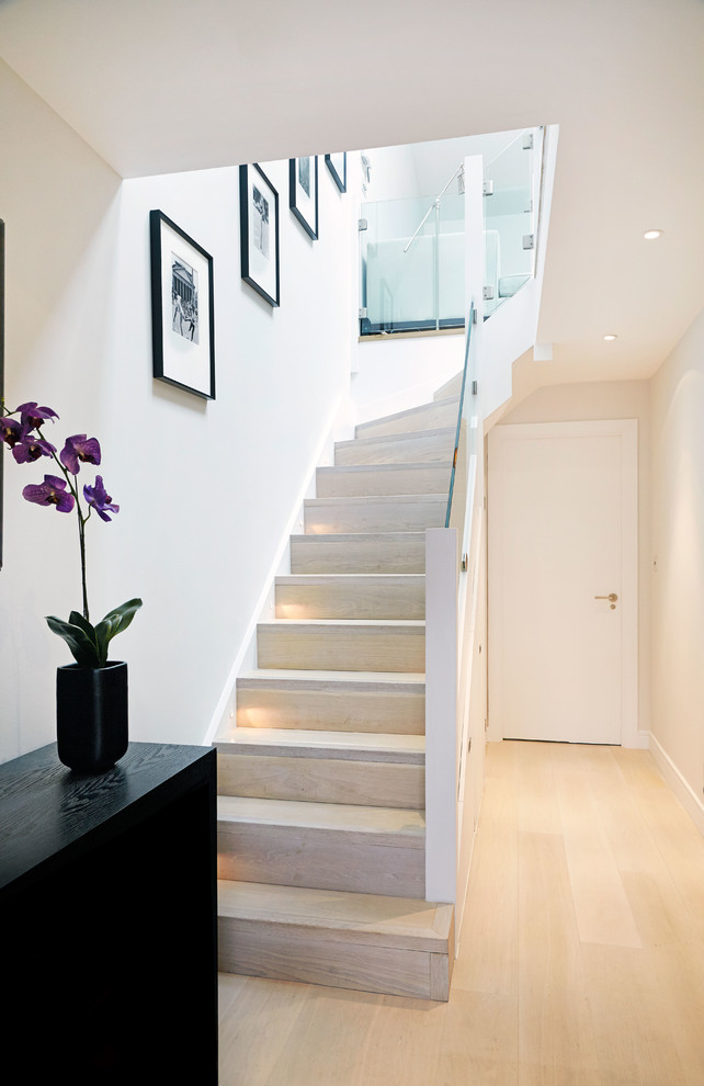 This is an example of a contemporary wood l-shaped staircase in London with wood risers.