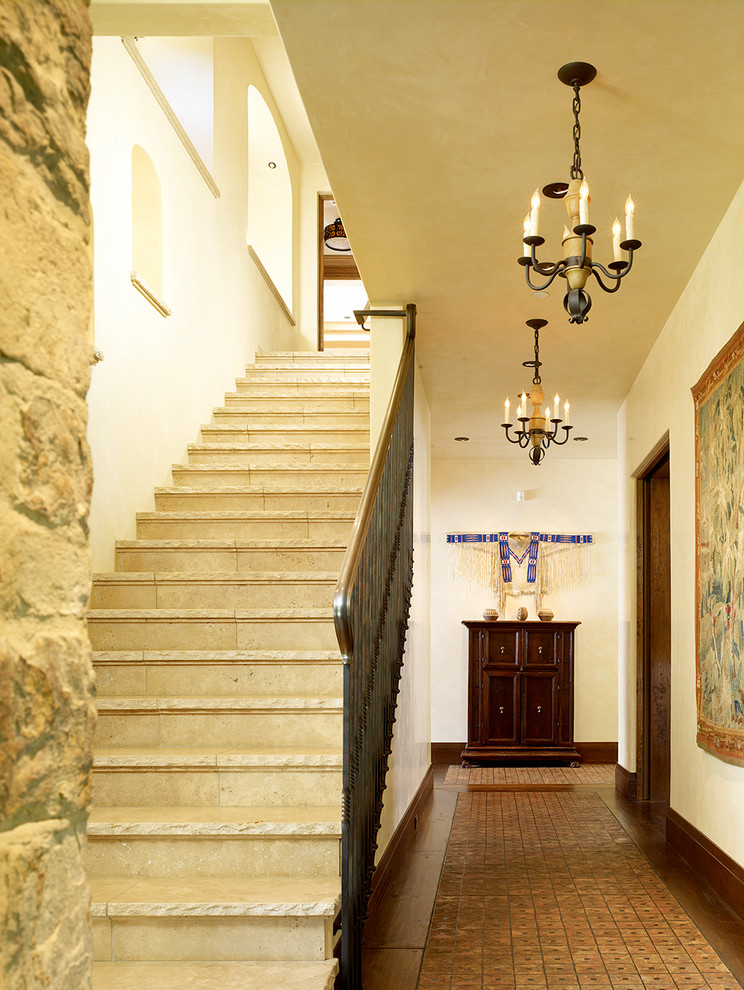 Mediterranean straight staircase in San Francisco with travertine treads and travertine risers.