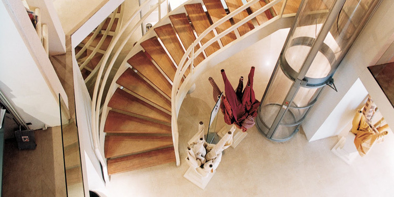 Свежая идея для дизайна: большая изогнутая лестница в современном стиле с деревянными ступенями, крашенными деревянными подступенками и металлическими перилами - отличное фото интерьера