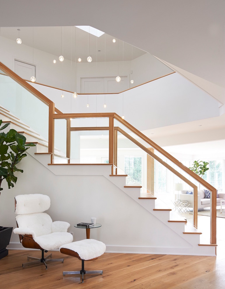 Пример оригинального дизайна: большая прямая лестница в стиле модернизм с деревянными ступенями и крашенными деревянными подступенками