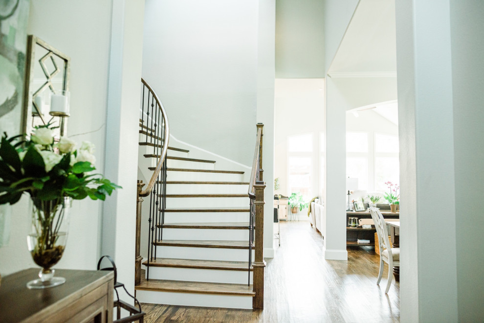 Example of a mid-sized transitional wooden curved metal railing staircase design in Dallas with wooden risers