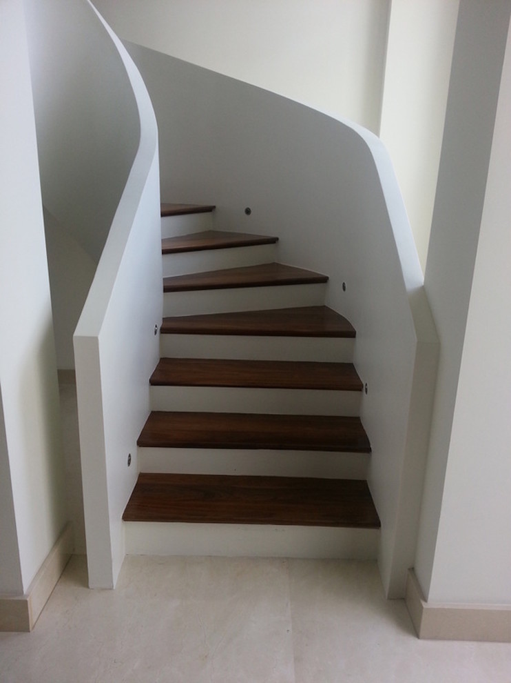 Aménagement d'un petit escalier courbe classique avec des marches en bois.