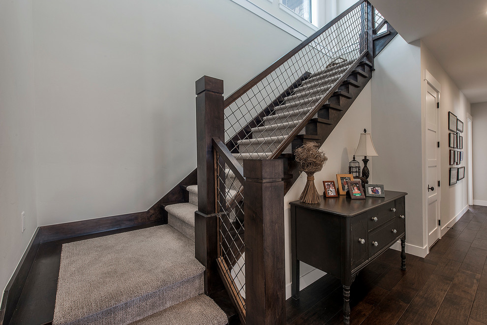 Aménagement d'un grand escalier classique en L avec des marches en moquette, des contremarches en moquette et un garde-corps en matériaux mixtes.