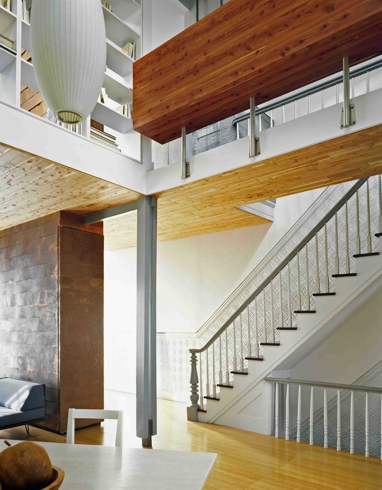 ニューヨークにある低価格の広いコンテンポラリースタイルのおしゃれな直階段 (木の蹴込み板) の写真