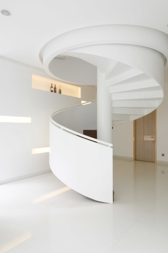 Foto de escalera de caracol minimalista de tamaño medio con escalones de madera y contrahuellas de madera